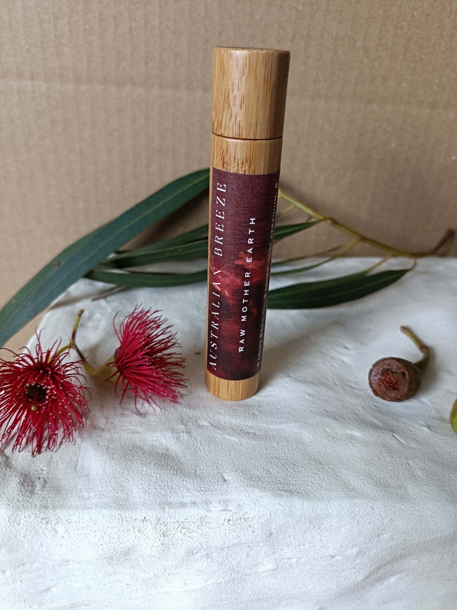 Roll-on -Perfume  with wooden cap on a textured surface with natural elements