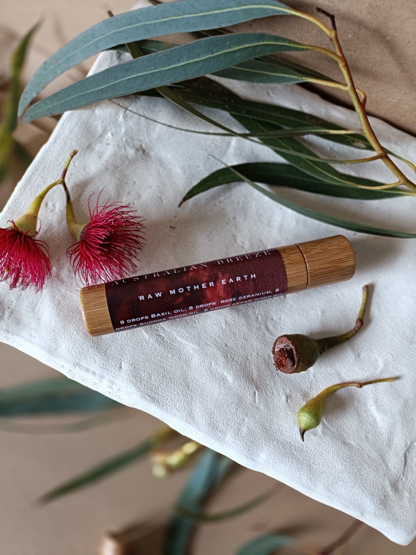 Roll-on-perfume with natural elements on a textured surface